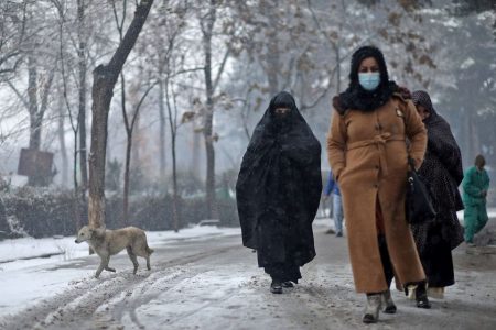 Afghan women walk on the street during a snowfall in Kabul, Afghanistan, January 3, 2022. REUTERS/Ali Khara