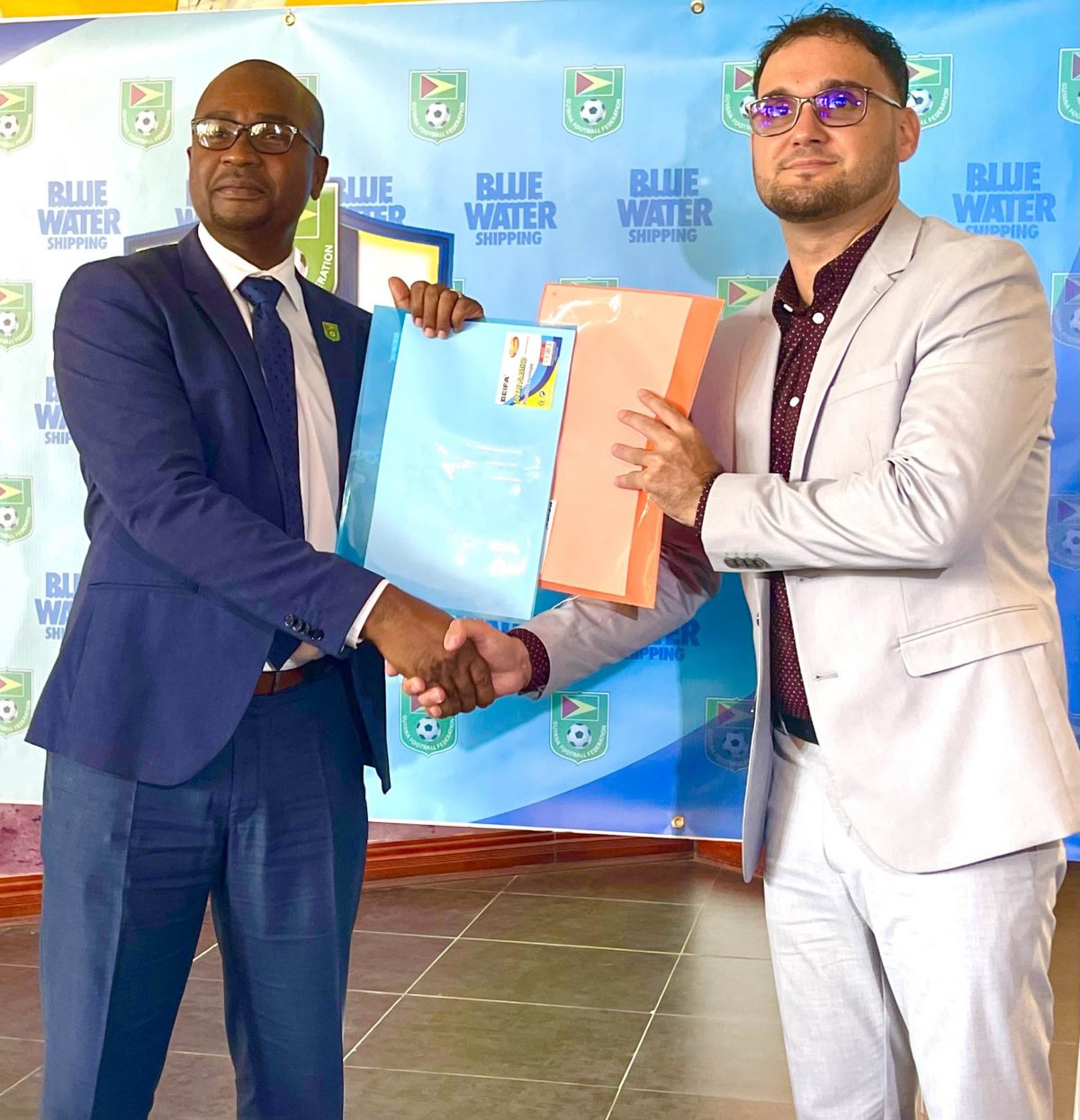 Inked! GFF President Wayne Forde (left) and Richard De Nobrega, Country Manager of Blue Waters Shipping, display the signed MoU which will pave the way for the staging of the Girls U15 Developmental League.