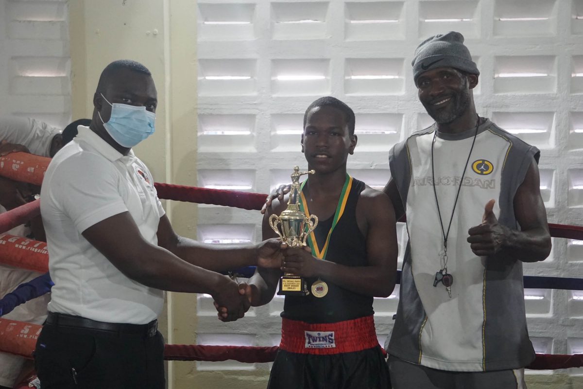Best Boxer! Jeremiah Duncan poses with his coach, Clifton Barker after being adjudged the best boxer of this year’s Pepsi/Mike Parris U-16 Championships was staged on Saturday at the Andrew ‘Sixhead’ Gym.