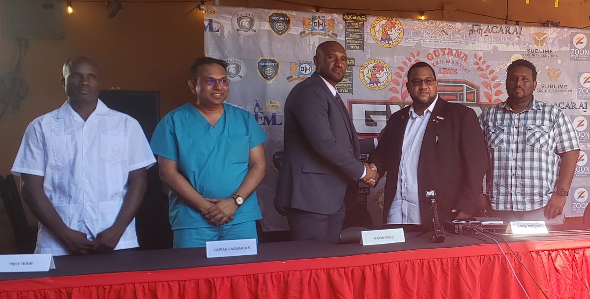 GMMAF President Gavin Singh (3rd from left) being congratulated by Caribbean Mixed Martials Arts Council Chairman Jason Fraser in the presence of several members of the local association inclusive of national coach Troy Bobb (left), Vice-President Dr. Sawan Jagnarain (2nd from left) and Vice-President Sherwin Sandy.