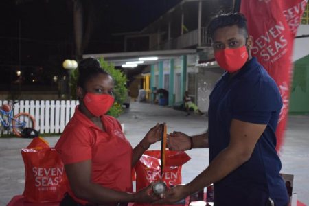 Men’s bare bow gold medallist: Jeewanram Persaud receives his prize from a Seven Seas representative.