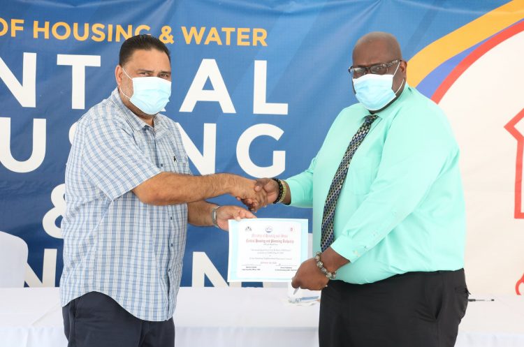 CHPA’s CEO, Sherwyn Greaves (right) handed over the symbolic key to Anand Kaladeen, Chairman of the NDC (CH&PA photo)