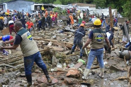 Neighbours join rescue workers in the hunt for survivors after a rain-weakened hillside collapsed over homes in Pereira, Colombia, on Tuesday, February 8, 2022. (AP Photo)