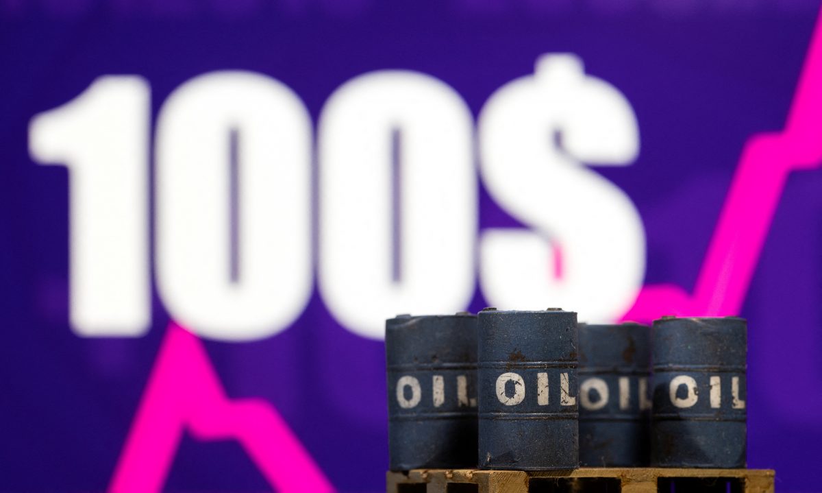 Models of oil barrel are seen in front of displayed rising stock graph and words "100 Dollars" in this illustration taken, February 23, 2022. REUTERS/Dado Ruvic/Illustration 