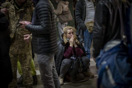 A woman reacts as she waits for a train trying to leave Kyiv, Ukraine, Thursday. Russian troops have launched their anticipated attack on Ukraine. Big explosions were heard before dawn in Kyiv, Kharkiv and Odesa as world leaders decried the start of a Russian invasion that could cause massive casualties and topple Ukraine's democratically elected government. [AP]