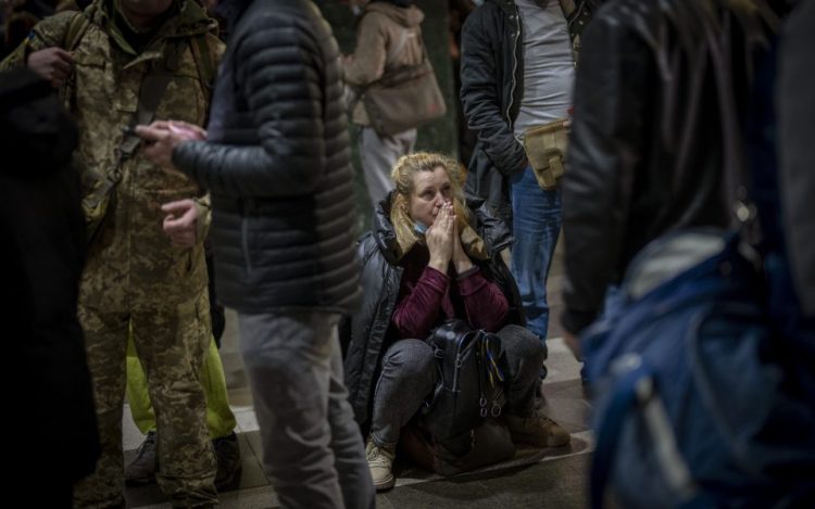 A woman reacts as she waits for a train trying to leave Kyiv, Ukraine, Thursday. Russian troops have launched their anticipated attack on Ukraine. Big explosions were heard before dawn in Kyiv, Kharkiv and Odesa as world leaders decried the start of a Russian invasion that could cause massive casualties and topple Ukraine's democratically elected government. [AP]