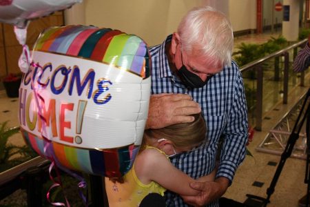 Charlotte Roempke, 8, welcomes her grandfather Bernie Edmonds as he arrives at Sydney International Airport after Australia reopened its international borders to travelers vaccinated against the coronavirus disease (Covid-19), in Sydney, Australia February 21, 2022.  Reuters