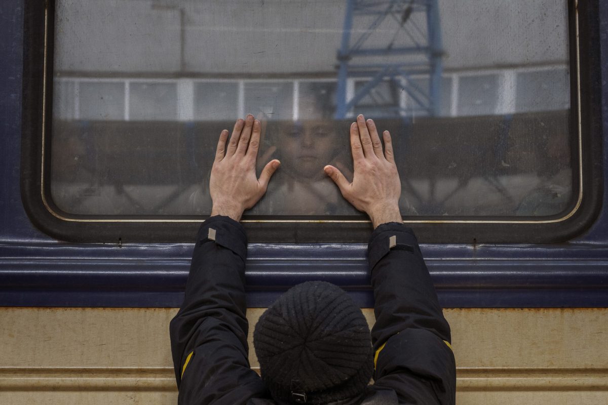 Aleksander, 41, presses his palms against the window as he says goodbye to his daughter Anna, 5, on a train to Lviv at the Kyiv station, Ukraine, Friday, March 4. 2022. Aleksander has to stay behind to fight in the war while his family leaves the country to seek refuge in a neighboring country. (AP Photo/Emilio Morenatti)