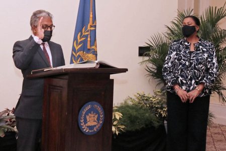 Reginald Armour SC recites the oath of office as he is sworn-in as the Attorney General and Minister of Legal Affairs at President’s House on Wednesday. Looking on is President Paula-Mae Weekes.