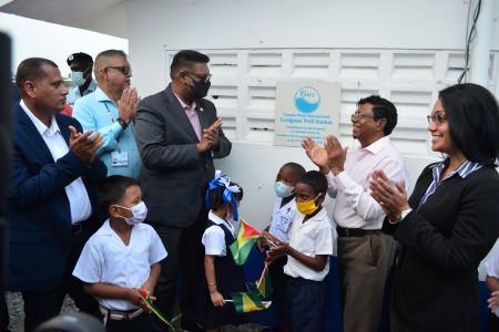 From left are Minister of Housing and Water Collin Croal, Chairman of GWI Board Ramesh Dookoo, and President Irfaan, who are Ali joined by (from right) Minister Susan Rodrigues , GWI CEO Sheik Baskh and pupils of Lusignan Primary to unveil the ceremonial plaque for the new well (Orlando Charles Photo)