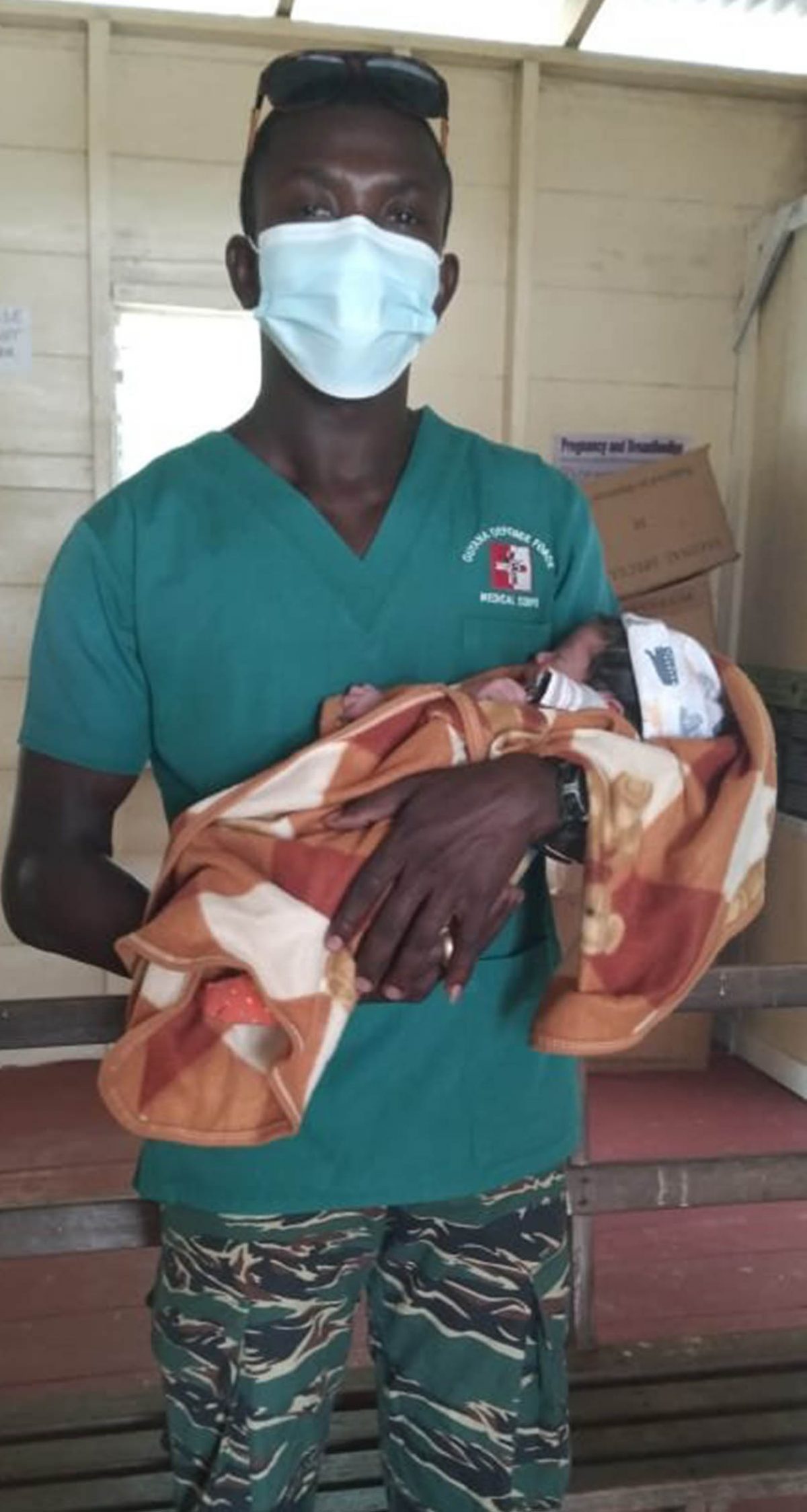 Guyana Defence Force Medic Corporal (CPL) Littleton Wilson holds the baby boy he helped deliver (GDF photo)