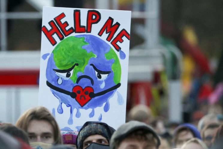 People carry a sign as they attend a protest during the UN Climate Change Conference (COP26), in Glasgow, Scotland, Britain, on 6th November, 2021. PICTURE: Reuters/Yves Herman/File photo.