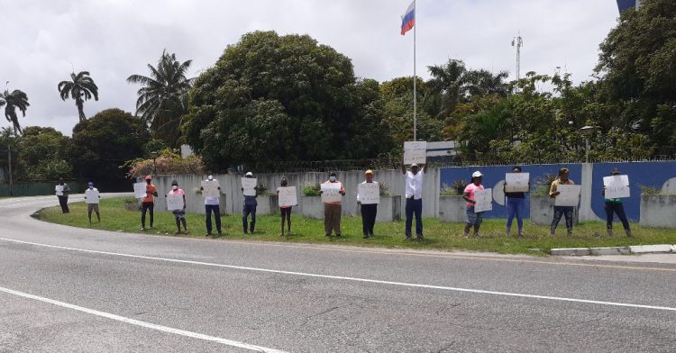 Protestors hold up placards outside of the Russian Embassy in Georgetown on Friday
