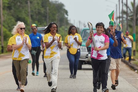 UNICEF Deputy Representative Irfan Akhtar is cheered by British High Commissioner Jane Miller (at left) and representatives of the Guyana Olympic Association as he carries The Queen’s Baton on Saturday into Linden during a part of the local leg of the Queen’s Baton Relay for the Commonwealth Games 2022. (UNICEF photo) 