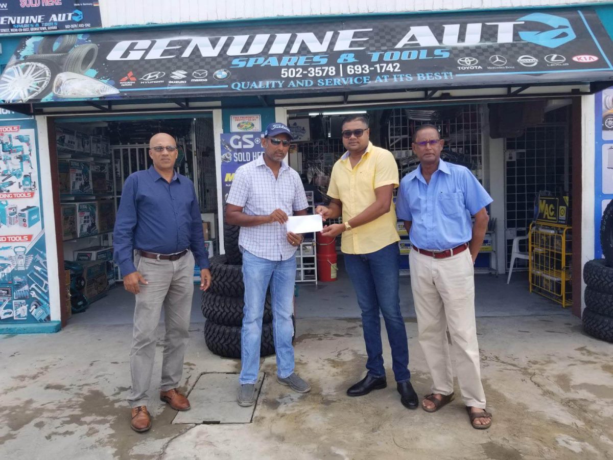 LGC Treasurer Maxim Mangra accepts a sponsor’s cheque from Managing Director Amrit Prashad (yellow shirt). On the left is President of LGC, Patangilee Persaud, while club captain, Patrick Prashad is on the right
