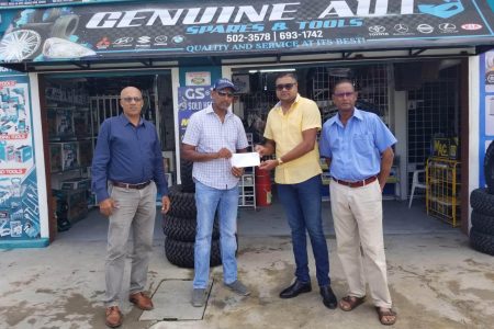 LGC Treasurer Maxim Mangra accepts a sponsor’s cheque from Managing Director Amrit Prashad (yellow shirt). On the left is President of LGC, Patangilee Persaud, while club captain, Patrick Prashad is on the right
