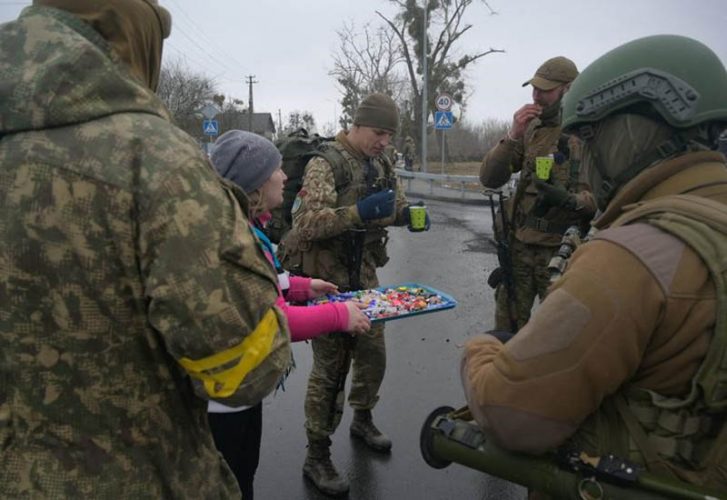 A woman offers sweets to Ukrainian servicemen, in the village of Yasnohorodka in the Kyiv region, Ukraine, March 2. REUTERS/Maksim Levin