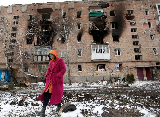 A woman walks in front of a residential building which was damaged during Ukraine-Russia conflict in the separatist-controlled town of Volnovakha in the Donetsk region, Ukraine March 11, 2022. (REUTERS)