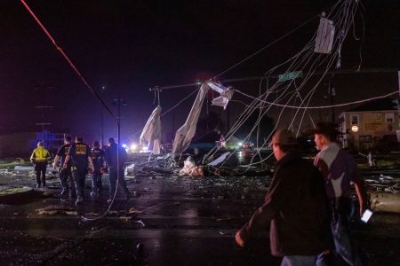 People walk past damaged infrastructure after a tornado struck in the Arabi neighborhood, St. Bernard Parish, New Orleans, Louisiana March 22, 2022. REUTERS/Kathleen Flynn