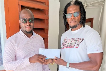 Dexter `Bushman ‘ Garnett, right hands over the donation  to organizer Rawle Toney.
