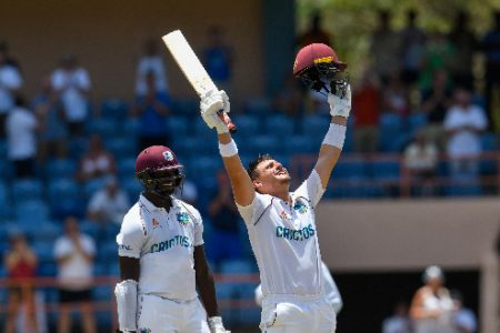 Joshua Da Silva celebrates his maiden Test century as Jayden Seales looks yesterday.