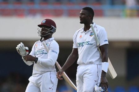 Jason Holder (right) and Nkrumah Bonner leave the field after steering West Indies to the safety of a draw on the final day.