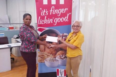 KFC representative, Pamela Manasseh hands over the sponsorship cheque to GMR&SC secretary Cheryl Gonsalves (right).