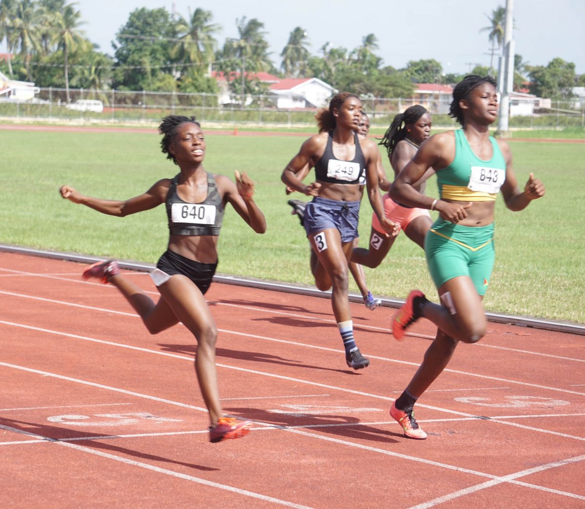 After a blistering start and a perfect drive phase, Karese Lloyd (lane 5) who clocked a personal best 11.84s was surpassed by the surging Keliza Smith (11.82) in the latter third of the 100m event. (Emmerson Campbell photo)