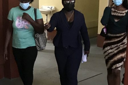 Steffany Dick (right) and her mother, Melanie Stewart (left) being guided by a woman constable 