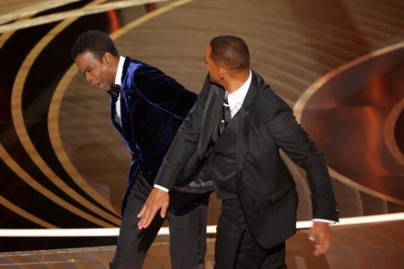 Chris Rock reacts after Will Smith hit him. REUTERS/Brian Snyder