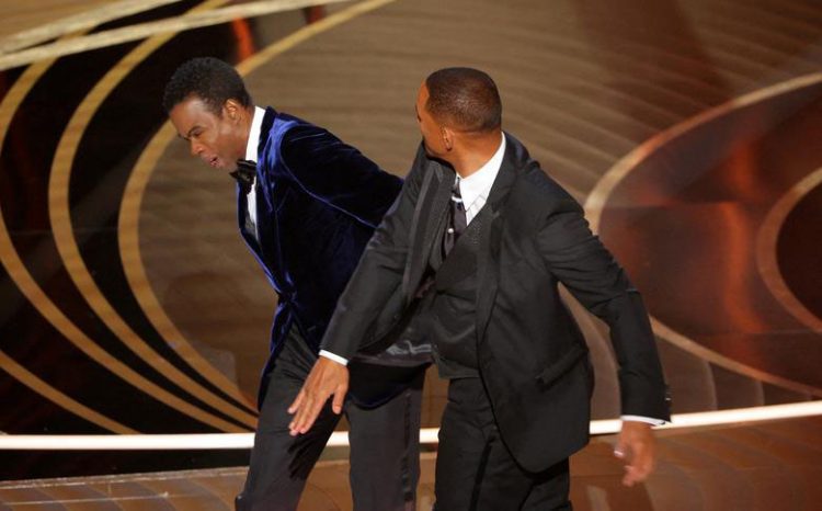 Chris Rock reacts after Will Smith hit him. REUTERS/Brian Snyder