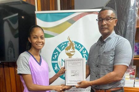 In the photograph, first vice president of the GBA, Dr. Marissa Parris, hands over the statement to chairman of the National Sports Commission, Kashif Muhammad.
