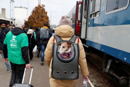 A person fleeing Russia's invasion of Ukraine carries a dog in a backpack to board a train in Zahony, Hungary March 3, 2022. REUTERS/Bernadett Szabo