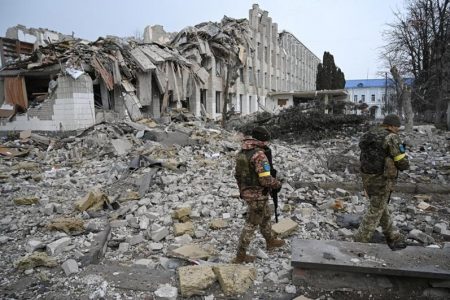Ukrainian service members walk near a school building destroyed by shelling in Zhytomyr, Ukraine March 4, 2022. REUTERS/Viacheslav Ratynskyi