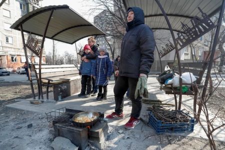 Residents prepare food in a yard in the besieged southern port of Mariupol, Ukraine, March 23.  REUTERS/Alexander Ermochenko