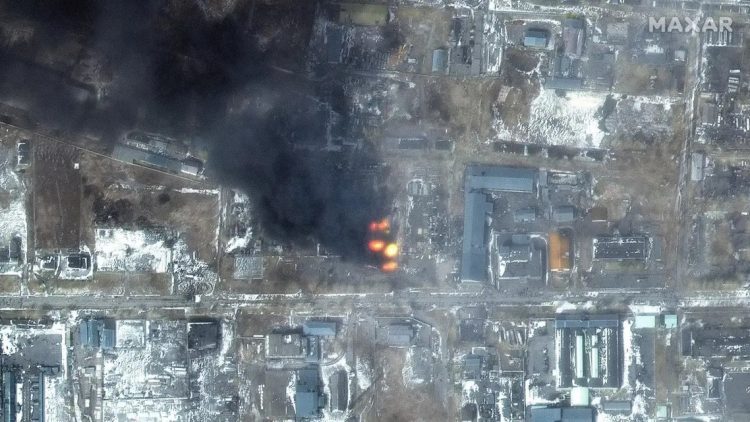 This Maxar satellite image taken and released on March 12, 2022, shows a multispectral view of fires in an industrial area of the Primorskyi district in western Mariupol, Ukraine. (AFP)