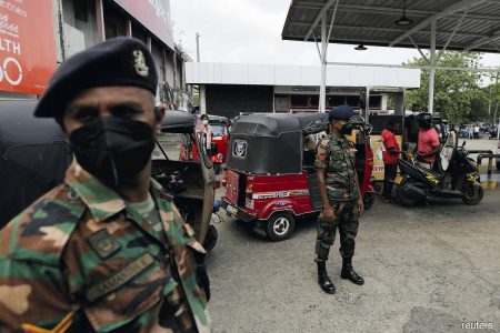 Sri Lanka's Army members stand guard at a Ceylon Petroleum Corp fuel station to help stations distribute oil during the fuel crisis, in Colombo, Sri Lanka on March 22