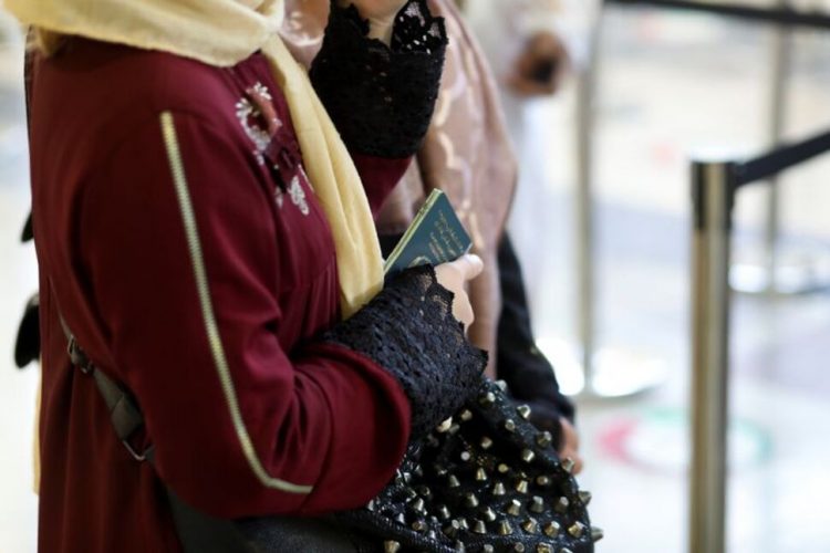 FILE PHOTO: An Afghan woman holds her passport at the international airport in Kabul, Afghanistan, September 9, 2021. WANA (West Asia News Agency) via REUTERS