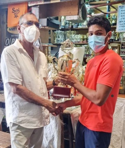 Chief Executive Officer of Trophy Stall Establishment Ramesh Sunich, left, hands over one of the champion rider trophies to Matthew Vieira.