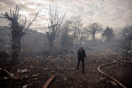 A woman walks between residential houses that were destroyed during shelling in a settlement outside Kharkiv as Russia’s attack on Ukraine continues, Ukraine.   REUTERS/Thomas Peter