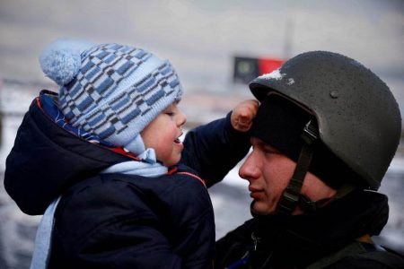 A police officer says goodbye to his son as his family flees from advancing Russian troops as Russia’s attack on Ukraine continues in the town of Irpin outside Kyiv, Ukraine, March 8. REUTERS/Thomas Peter