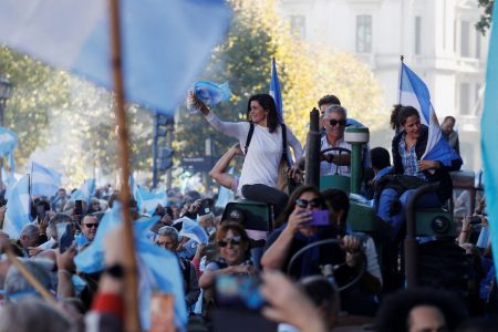 People hold Argentine flags as farmers ride tractors at Plaza de Mayo to protest new export taxes on farm goods applied by President Alberto Fernandez’s administration, in Buenos Aires, Argentina April 23, 2022. (REUTERS/Agustin Marcarian photo)
