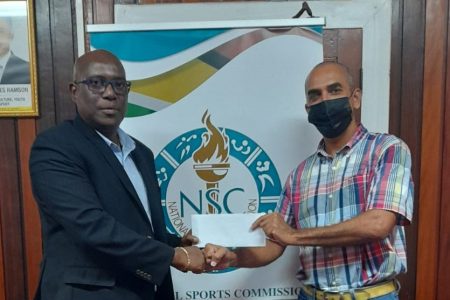 NSC Director of Sport Steve Ninvalle (left) presenting the cheque to GASA Honorary Treasurer Valmiki Singh to aid in Guyana’s participation at the 35th CARIFTA Swimming Championships.