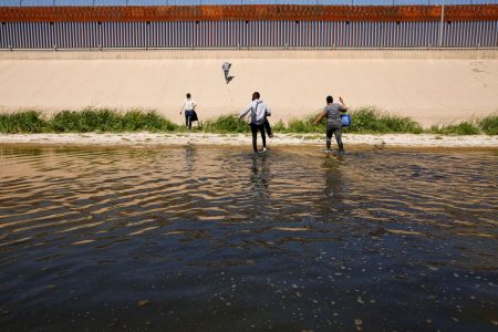 Asylum-seeking migrants walk out of the Rio Bravo river after crossing it to turn themselves in to U.S Border Patrol agents to request asylum in El Paso, Texas, U.S., as seen from Ciudad Juarez, Mexico April 13, 2022. REUTERS/Jose Luis Gonzalez