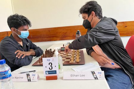 Ethan Lee (left) and Ricardo Narine battling in their earlier pool match in the National Junior Chess Championship