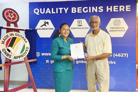 Head of GNBS Certification Department Andrea Mendonca handing the certificate to CEO of APFI, Louis Holder   