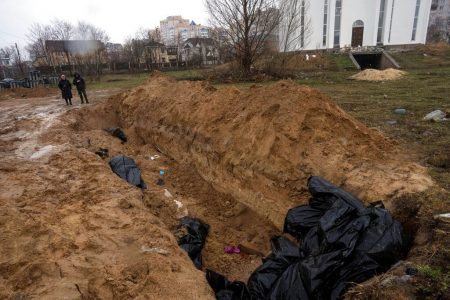 Neighbours gather next to a mass grave in Bucha, in the outskirts of Kyiv, Ukraine, on, April 3, 2022. Rodrigo Abd—AP
