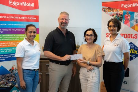 ExxonMobil Guyana’s Safety Manager Brad Edlington hands over the cheque to UWSC President Jennifer Prashad with other members of the organisation in attendance