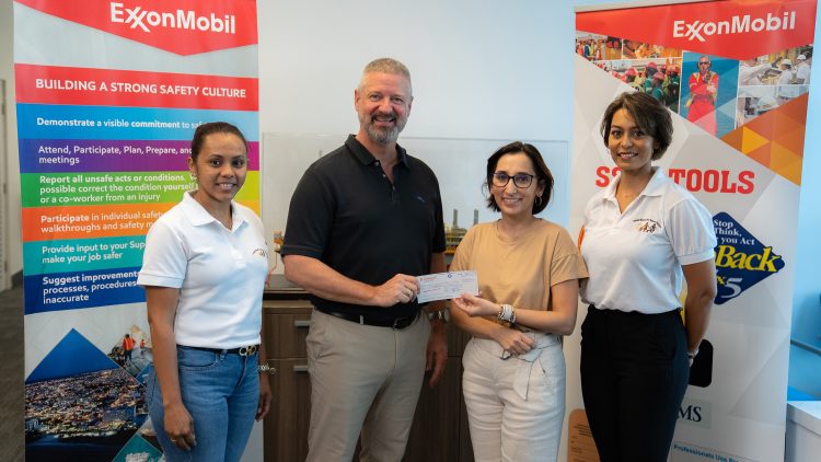 ExxonMobil Guyana’s Safety Manager Brad Edlington hands over the cheque to UWSC President Jennifer Prashad with other members of the organisation in attendance