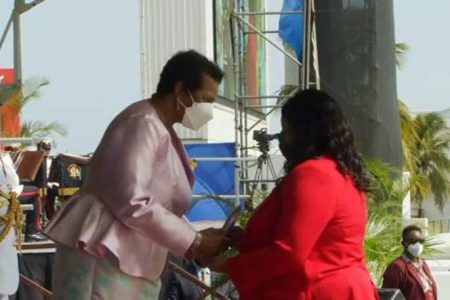 Geneva Tyndall, acting Consul General of Guyana, receives the Award – a Humanitarian Plaque - from President of Barbados Dame Sandra Mason 